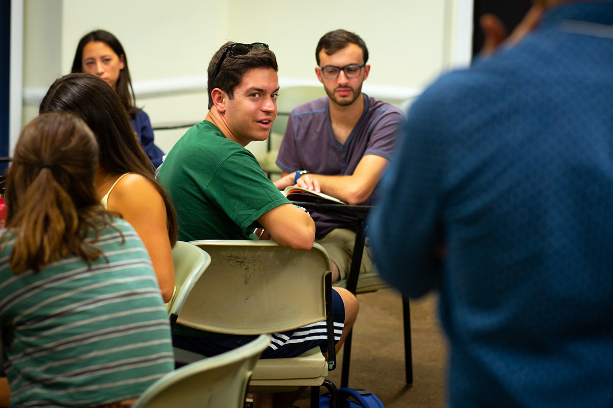 Student talking during a group discussion in a classroom.