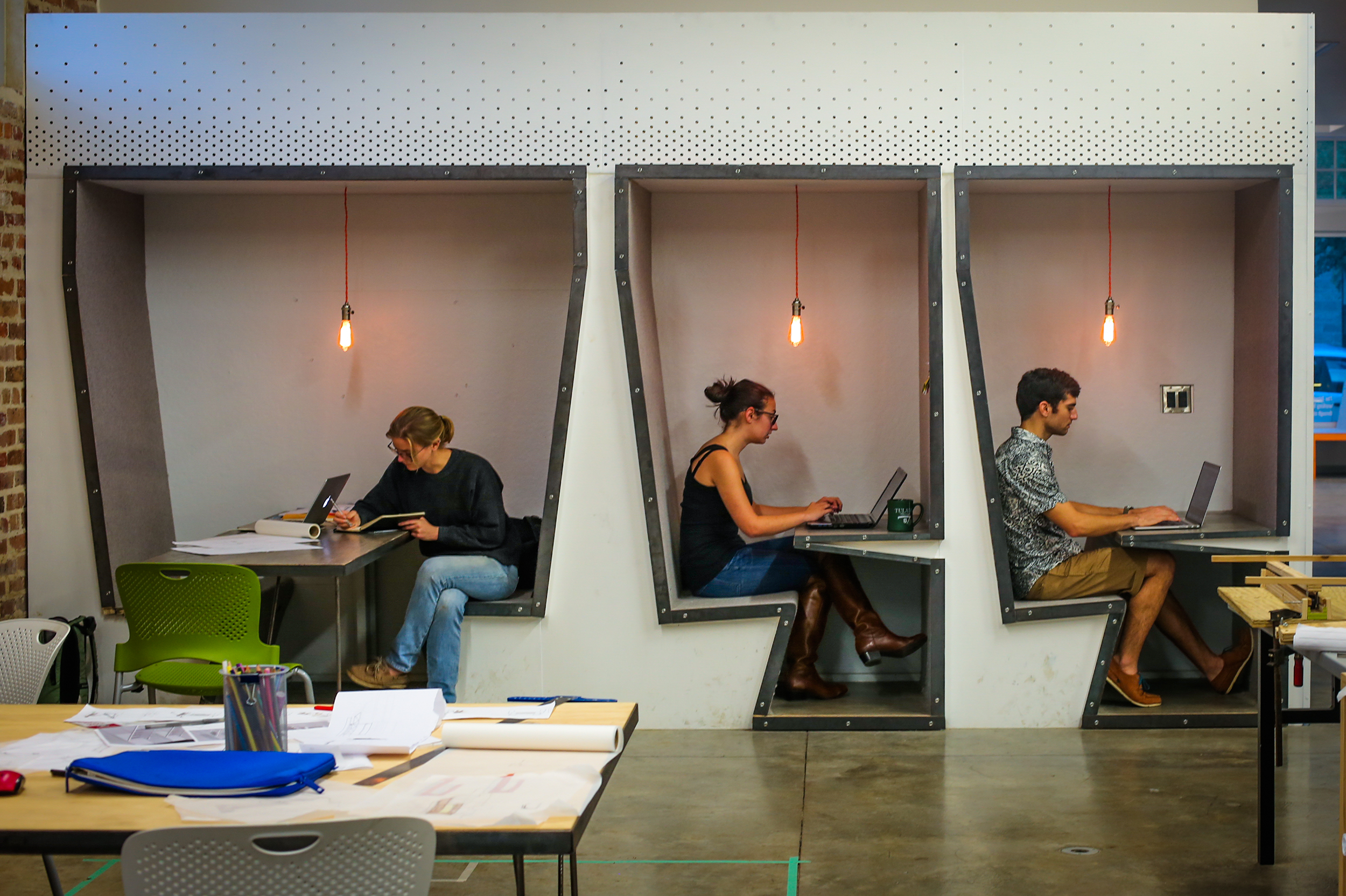 Three students studying in three booths. 