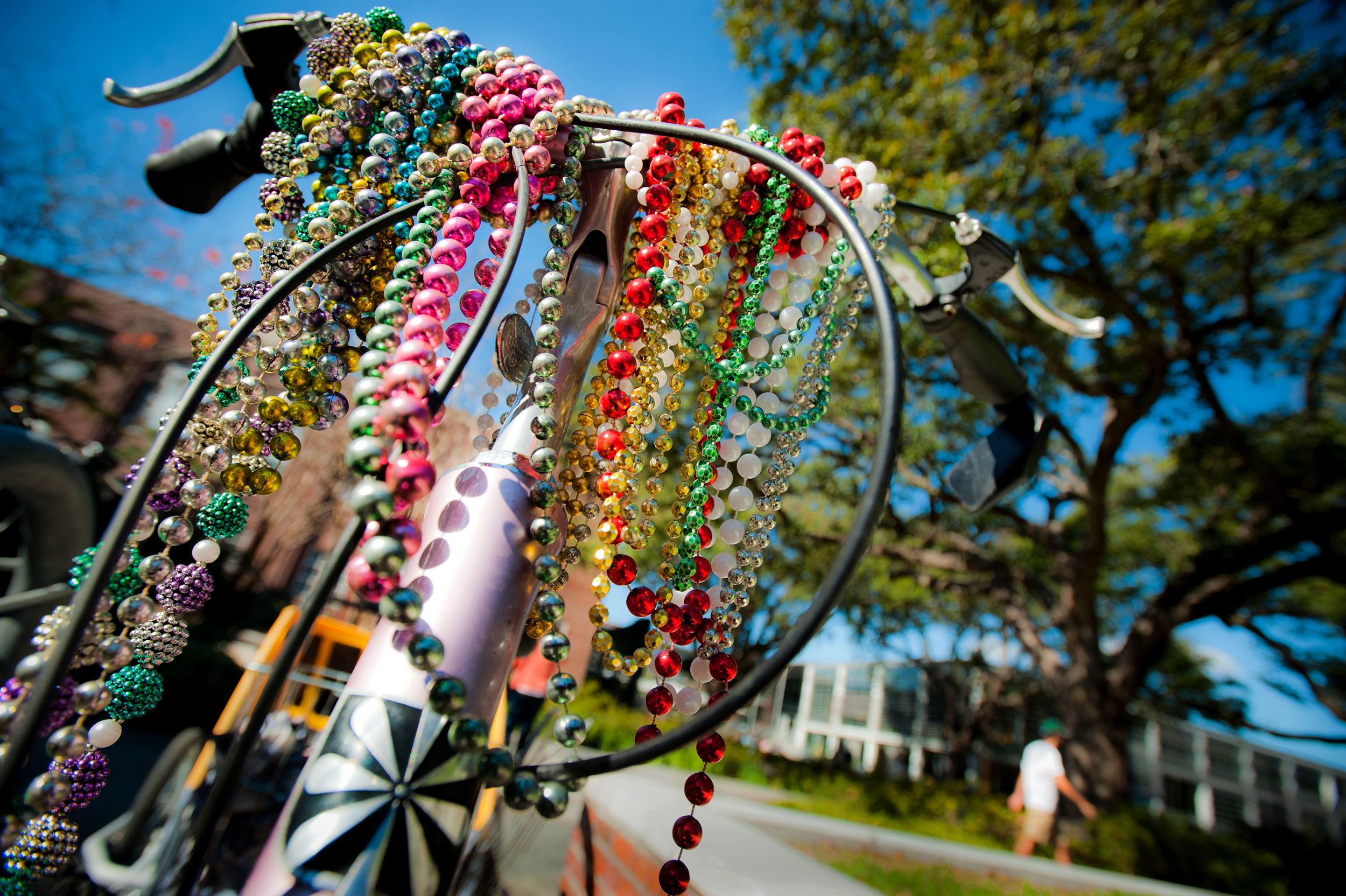 Mardi Gras beads dangling off front bicycle handle.