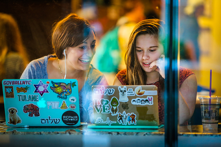 Two female students at the PJ's Coffee on Willow with their laptops open.