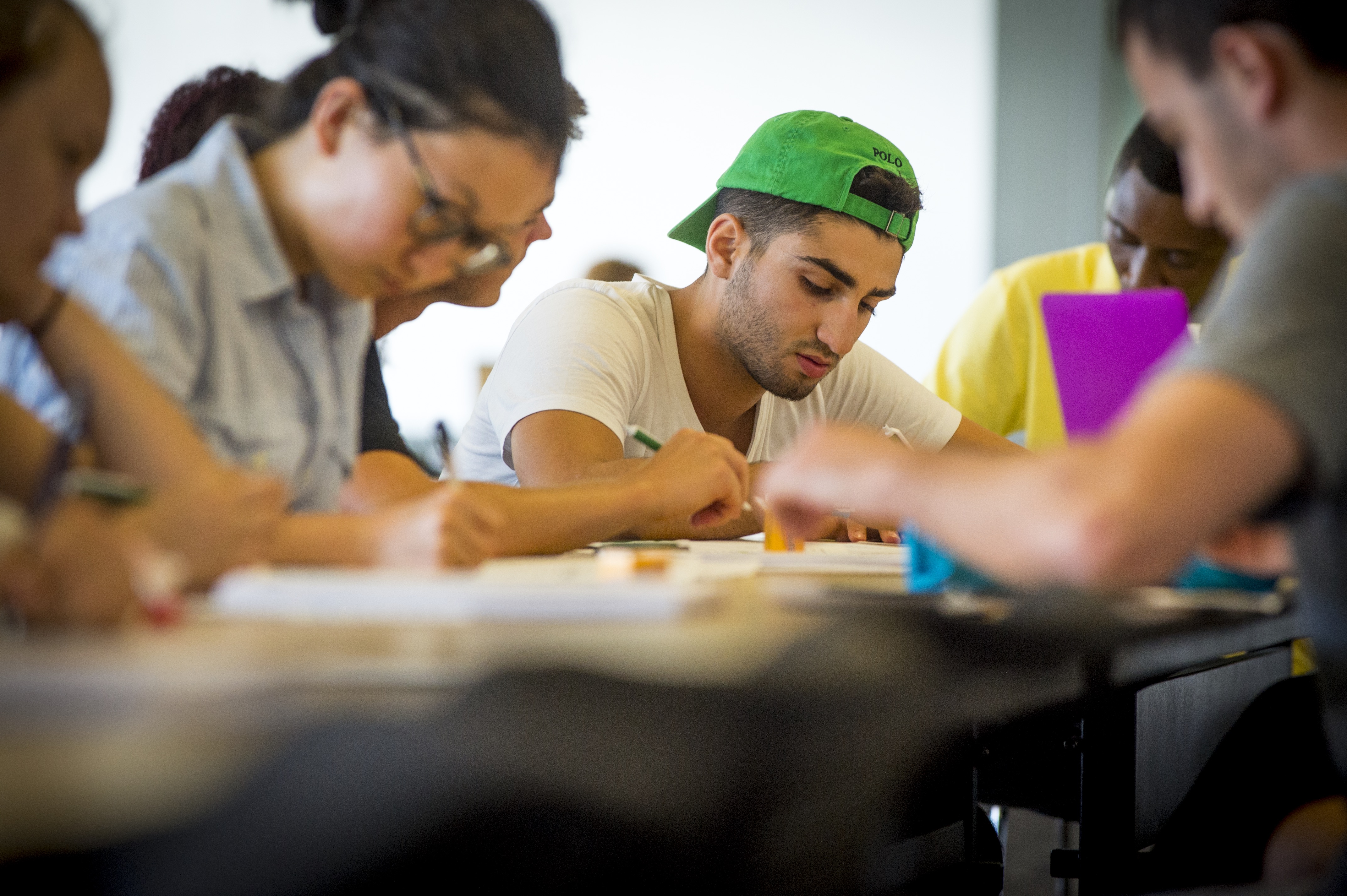 Student writing at a table.