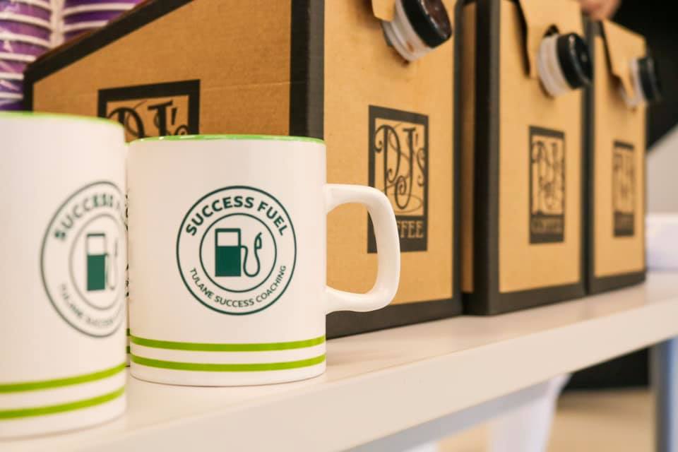 Student Success coffee mug next to carton of Community Coffee.