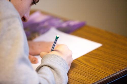 Student writing on paper.