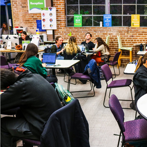 Students at tables in the tutoring center. 